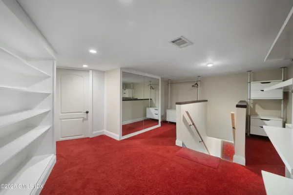 a bedroom with a bed chair and a large window