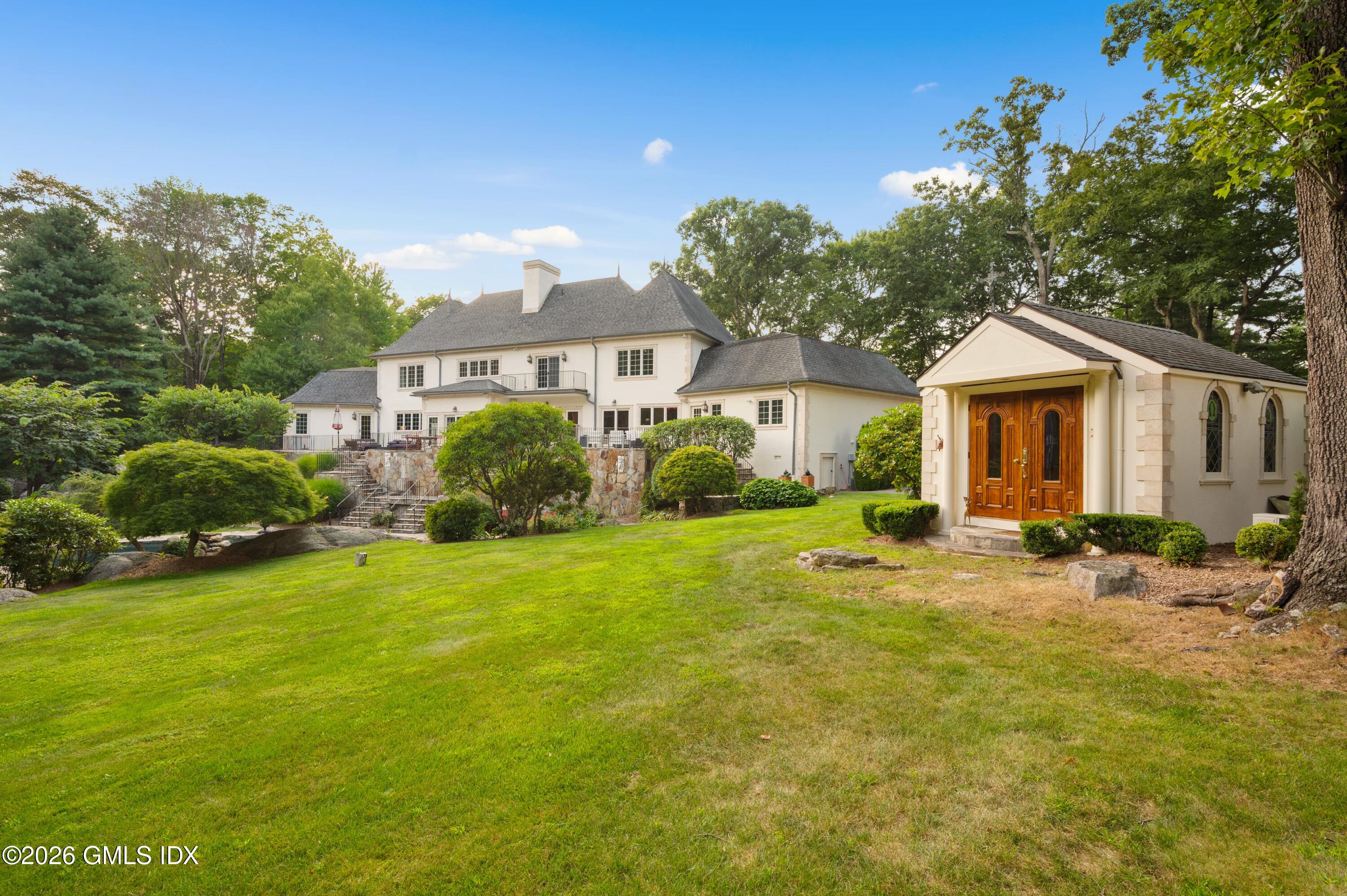 367 Riversville Road Greenwich, CT 06831 - Photo 57 of 66 a front view of a house with yard and green space
