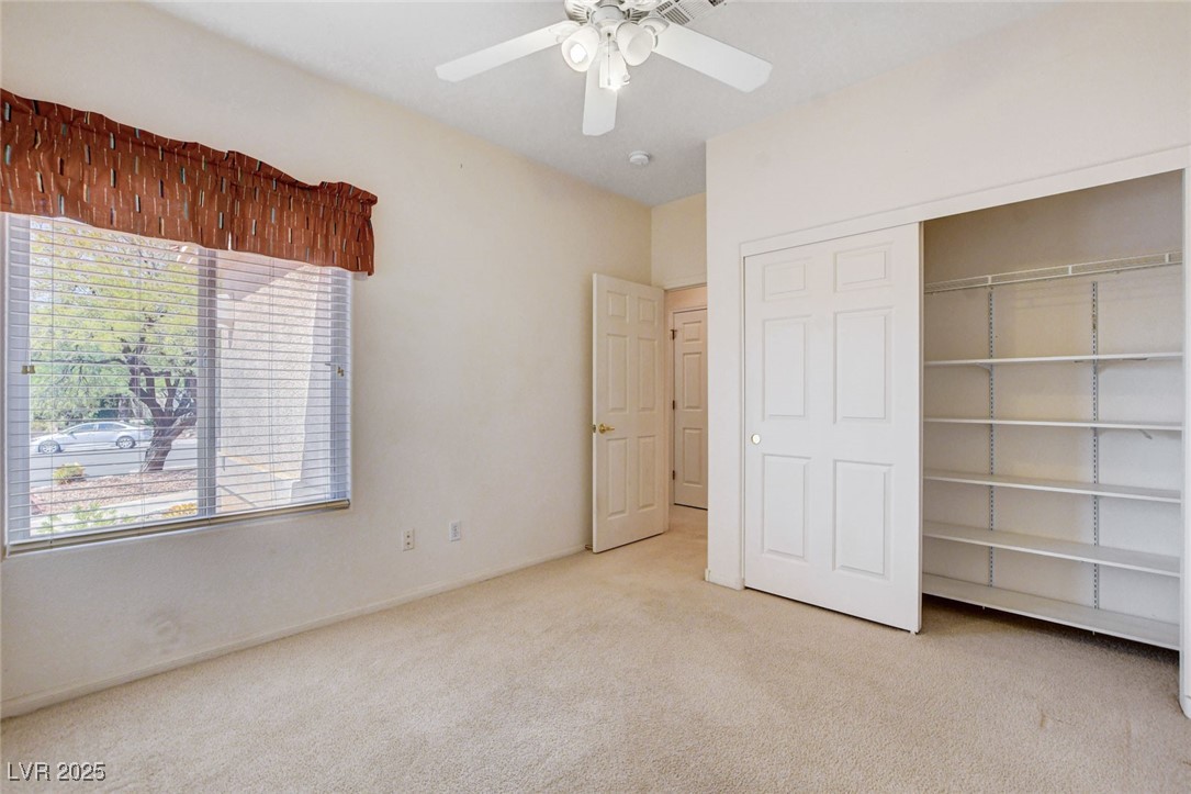 1104 Endora Way Boulder City, NV 89005 - Photo 15 of 36 Unfurnished bedroom featuring light carpet, ceiling fan, and a closet