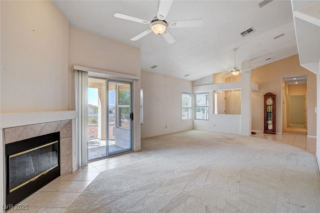1104 Endora Way Boulder City, NV 89005 - Photo 3 of 36 Unfurnished living room featuring light tile patterned flooring, a fireplace, light colored carpet, and high vaulted ceiling
