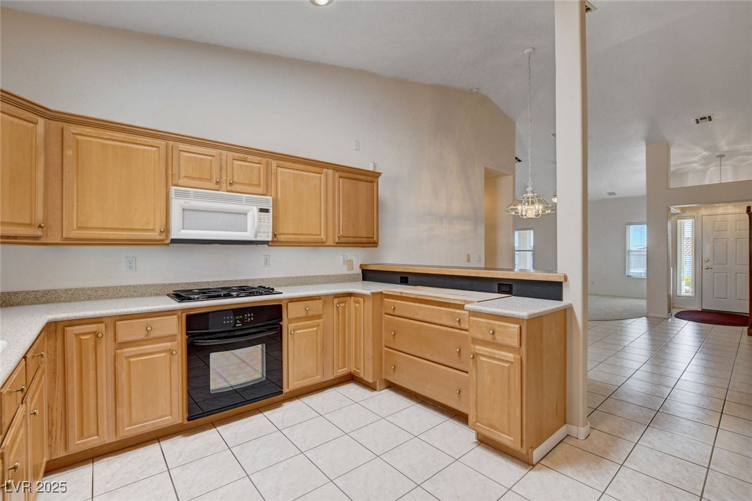 1104 Endora Way Boulder City, NV 89005 - Photo 36 of 36 Kitchen featuring light tile patterned flooring, black appliances, a peninsula, decorative light fixtures, and open floor plan