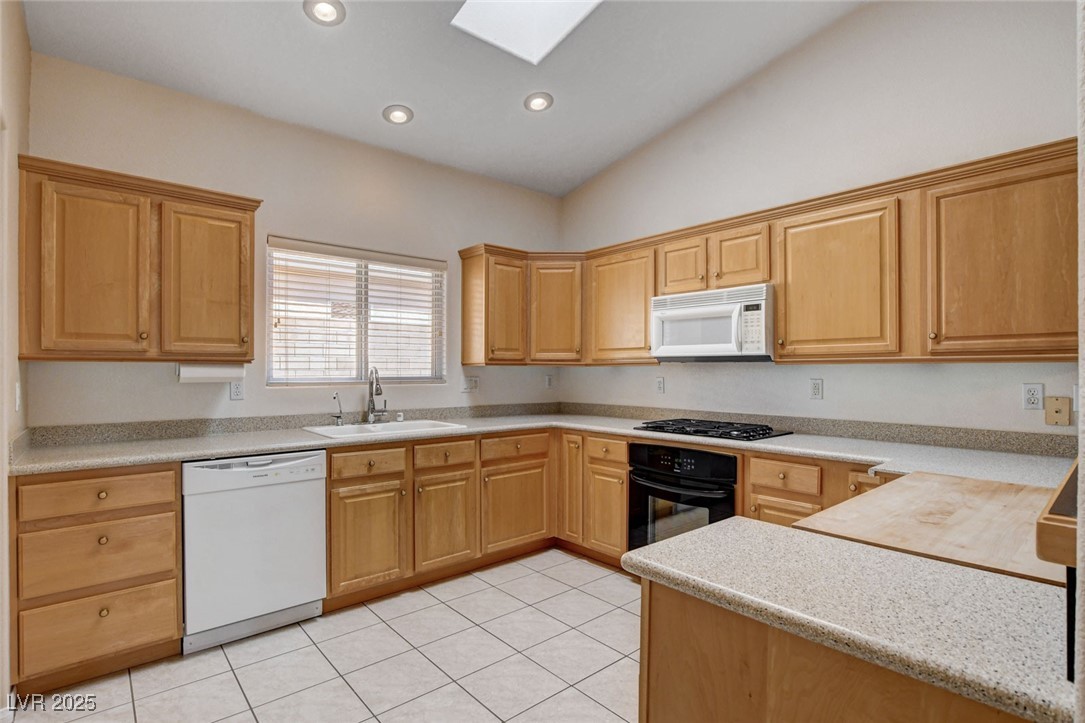 1104 Endora Way Boulder City, NV 89005 - Photo 7 of 36 Kitchen featuring a skylight, black appliances, light tile patterned floors, recessed lighting, and lofted ceiling
