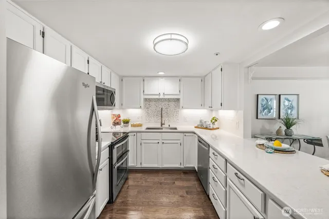 a kitchen with stainless steel appliances a refrigerator sink and cabinets