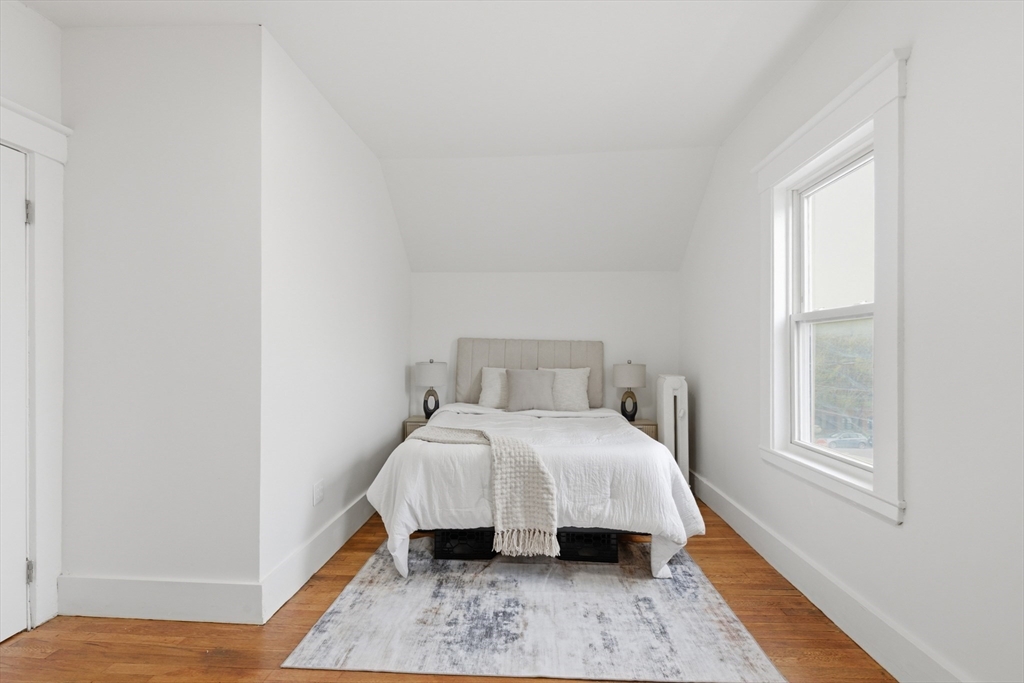 9 Robbins Street Waltham, MA 02453 - Photo 21 of 42 a bed sitting in a bedroom next to a window