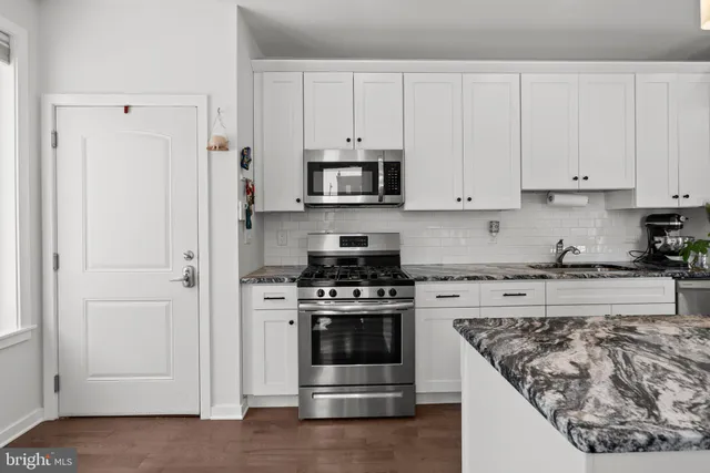 a kitchen with stainless steel appliances granite countertop a stove and a refrigerator