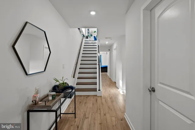 a view of a hallway with wooden floor and entryway