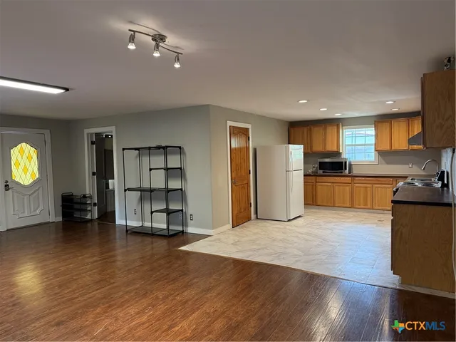 an empty room with wooden floor and window