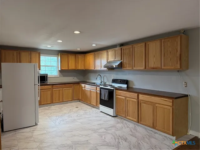 a kitchen with stainless steel appliances a stove a sink and a microwave
