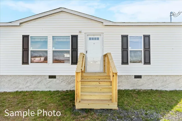 a view of front door of house with a yard