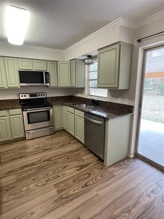 a kitchen with stainless steel appliances granite countertop a stove a sink and a microwave