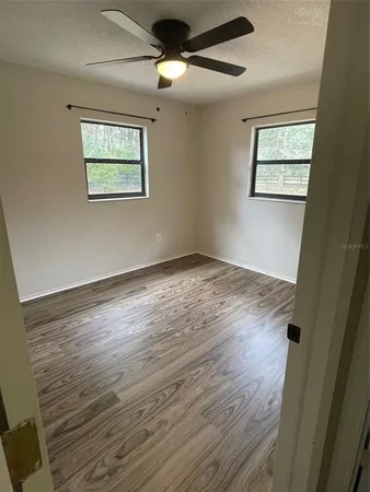 a view of empty room with wooden floor