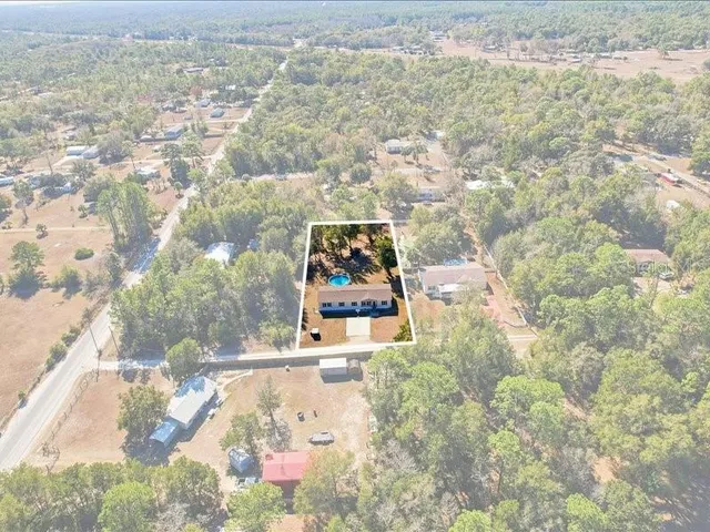 a front view of a house with yard and tree in it