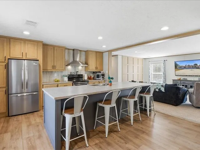 a kitchen with granite countertop a stove a sink and a refrigerator
