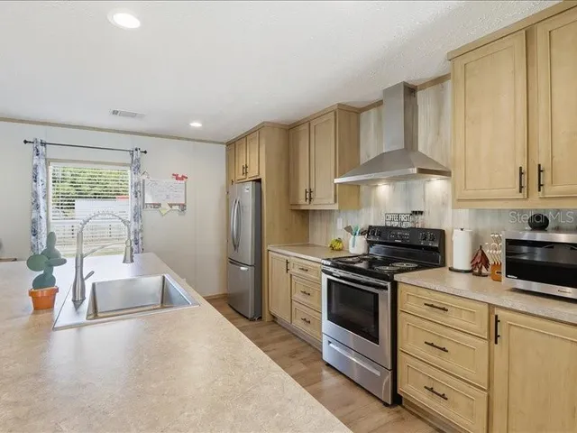 a kitchen with stainless steel appliances granite countertop a sink stove and refrigerator