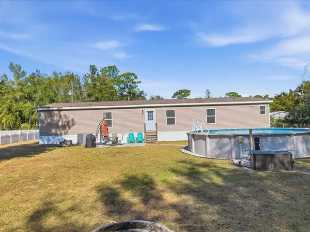 a view of a house with pool and a yard