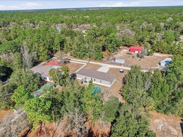 an aerial view of a house with garden space and sitting area