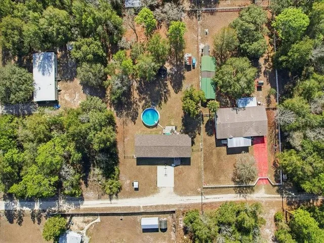 an aerial view of residential houses with outdoor space and trees