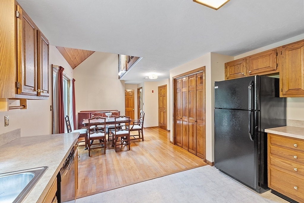 58 Peabody Road, Unit B Shirley, MA 01464 - Photo 16 of 38 a kitchen with stainless steel appliances granite countertop a refrigerator stove top oven dining table and chairs