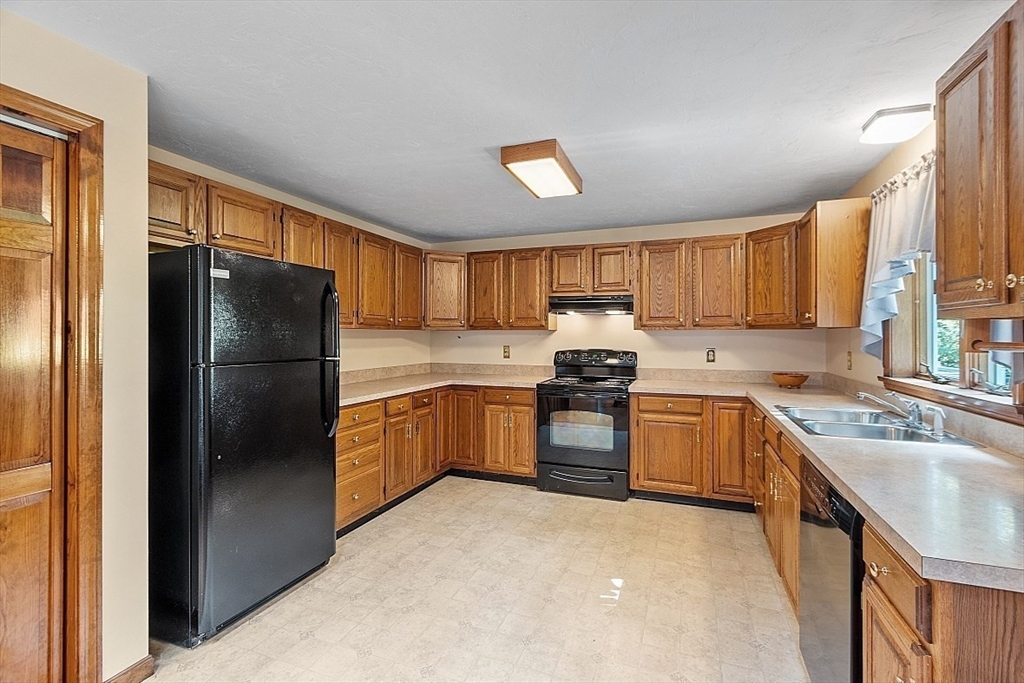 58 Peabody Road, Unit B Shirley, MA 01464 - Photo 17 of 38 a kitchen with granite countertop stainless steel appliances a refrigerator a sink a stove a microwave and cabinets