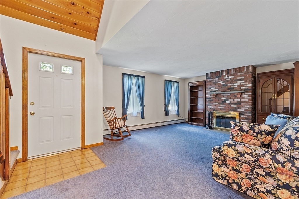58 Peabody Road, Unit B Shirley, MA 01464 - Photo 6 of 38 a living room with furniture a fireplace and a flat screen tv