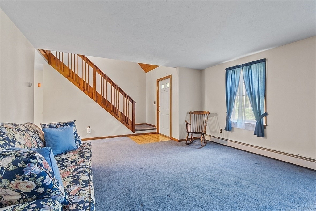 58 Peabody Road, Unit B Shirley, MA 01464 - Photo 9 of 38 a view of an empty room with wooden floor and stairs