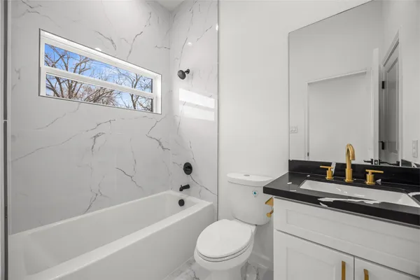 a bath room with a toilet a sink and a bath tub