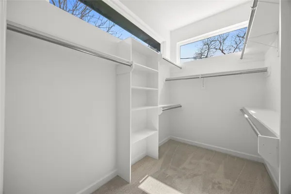 a view of walk in closet with empty racks