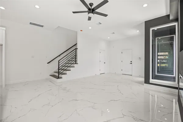 an empty room with fan and windows