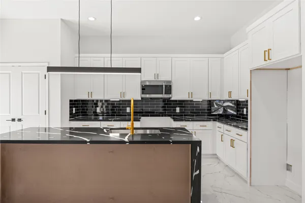 a kitchen with stainless steel appliances granite countertop a stove a sink and a refrigerator