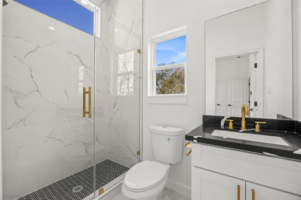 a bathroom with a toilet a sink and a shower