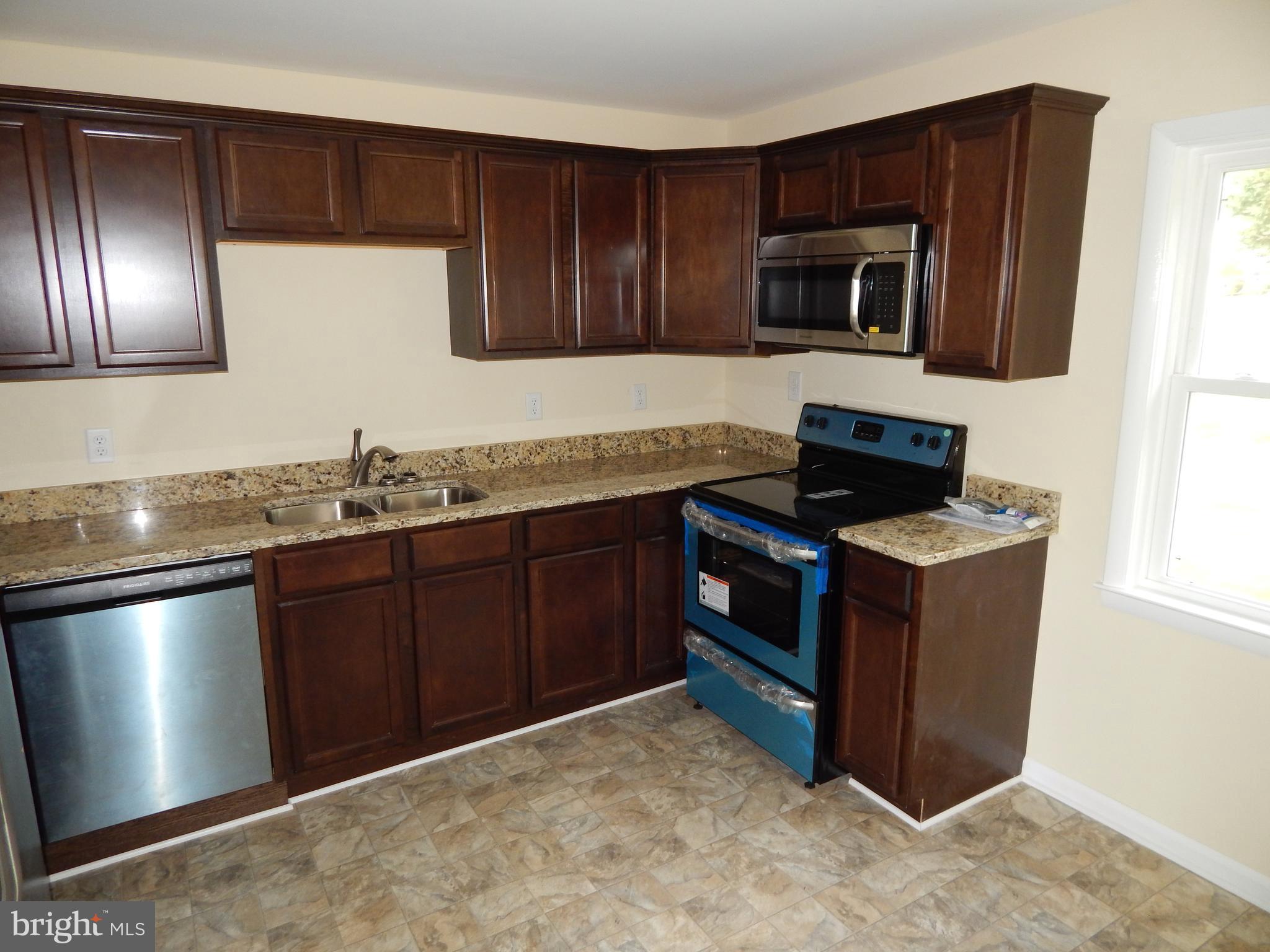 138 Lemon Road Ranson, WV 25438 - Photo 2 of 29 a kitchen with stainless steel appliances granite countertop a stove a microwave and wooden cabinets
