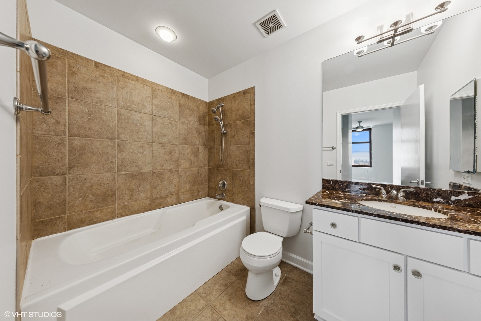 233 East 13th Street, Unit 2210 Chicago, IL 60605 - Photo 6 of 28 a bathroom with a granite countertop bathtub shower sink mirror vanity and toilet