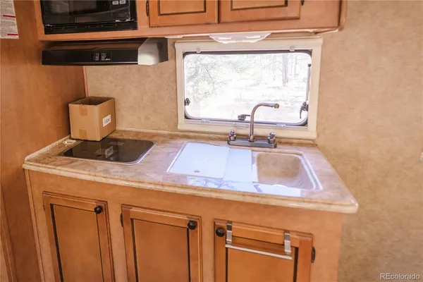 a kitchen with a sink cabinets and a window