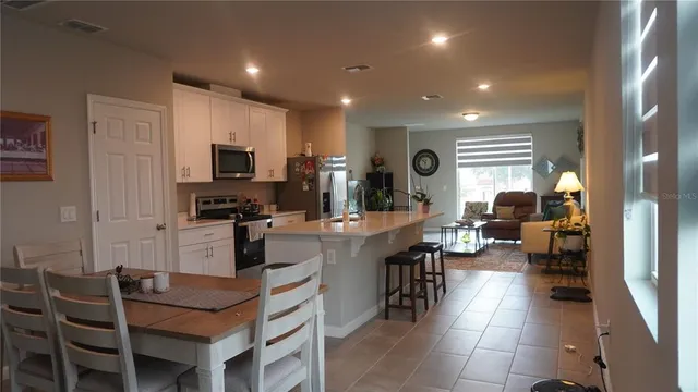 a large white kitchen with lots of counter space and stainless steel appliances