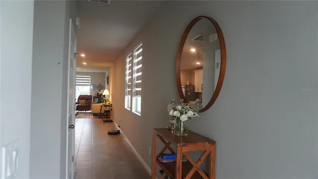 wooden floor in a room with a mirror and lamp