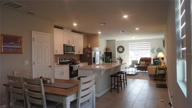 a very nice looking open dining room with kitchen island granite countertop a table and chairs
