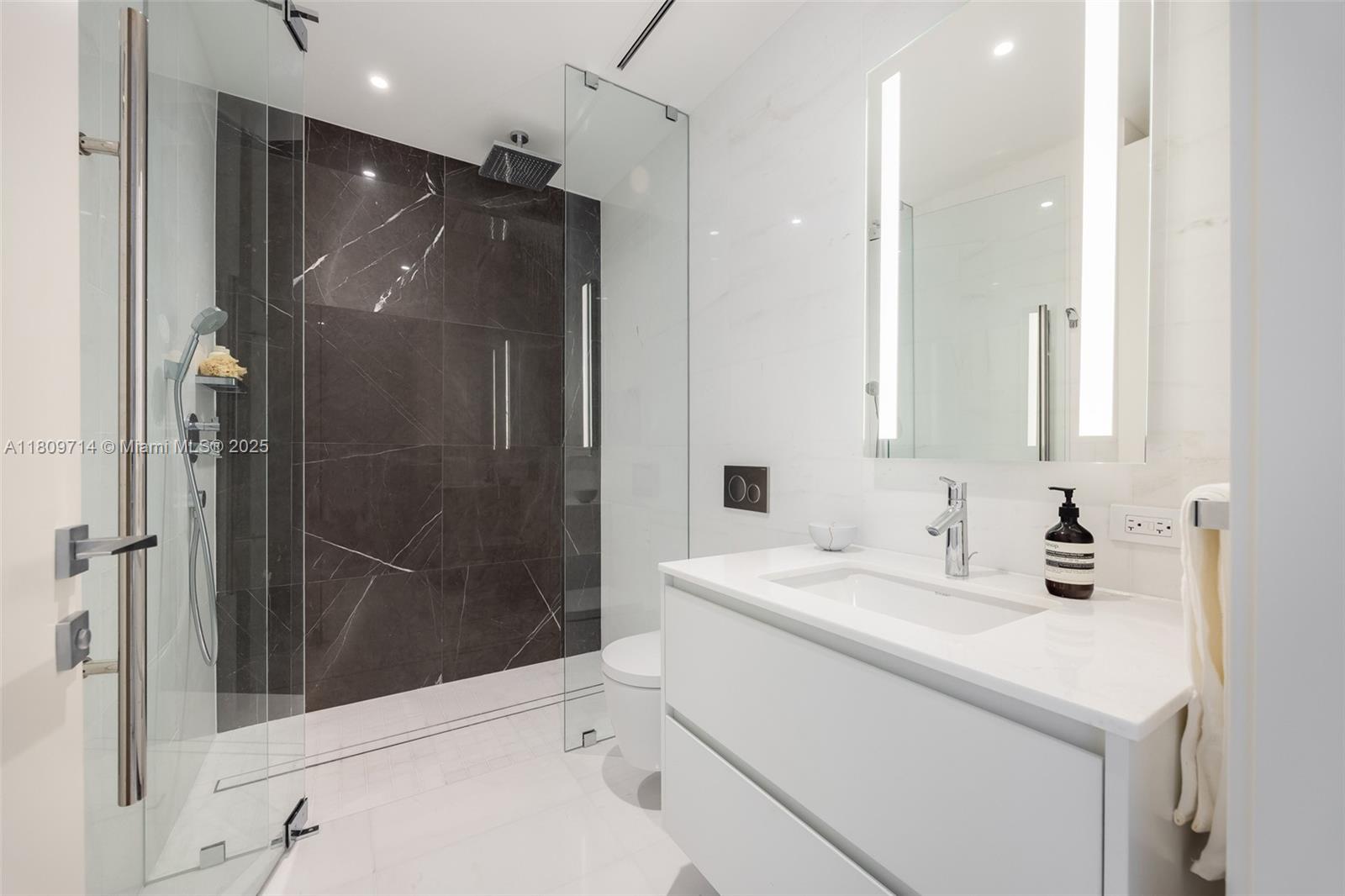 300 Biscayne Blvd Way, Unit 5205W Miami, FL 33131 - Photo 18 of 40 a bathroom with a shower sink and mirror