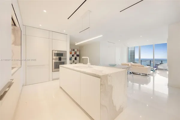 a kitchen with kitchen island a sink appliances and cabinets
