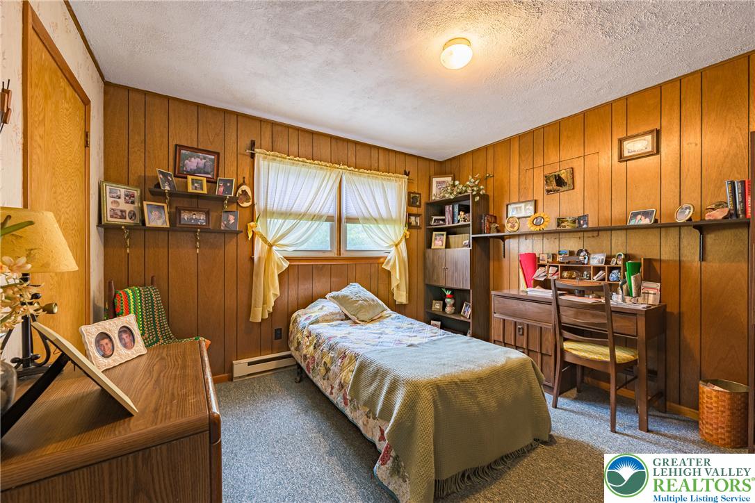 678 Interchange Road Kresgeville, PA 18333 - Photo 23 of 45 This cozy bedroom features warm wood paneling, offering a tranquil retreat with ample natural light.