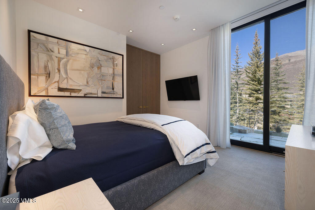 254 Beaver Dam Road Vail, CO 81657 - Photo 35 of 46 a spacious bedroom with a bed and glass window
