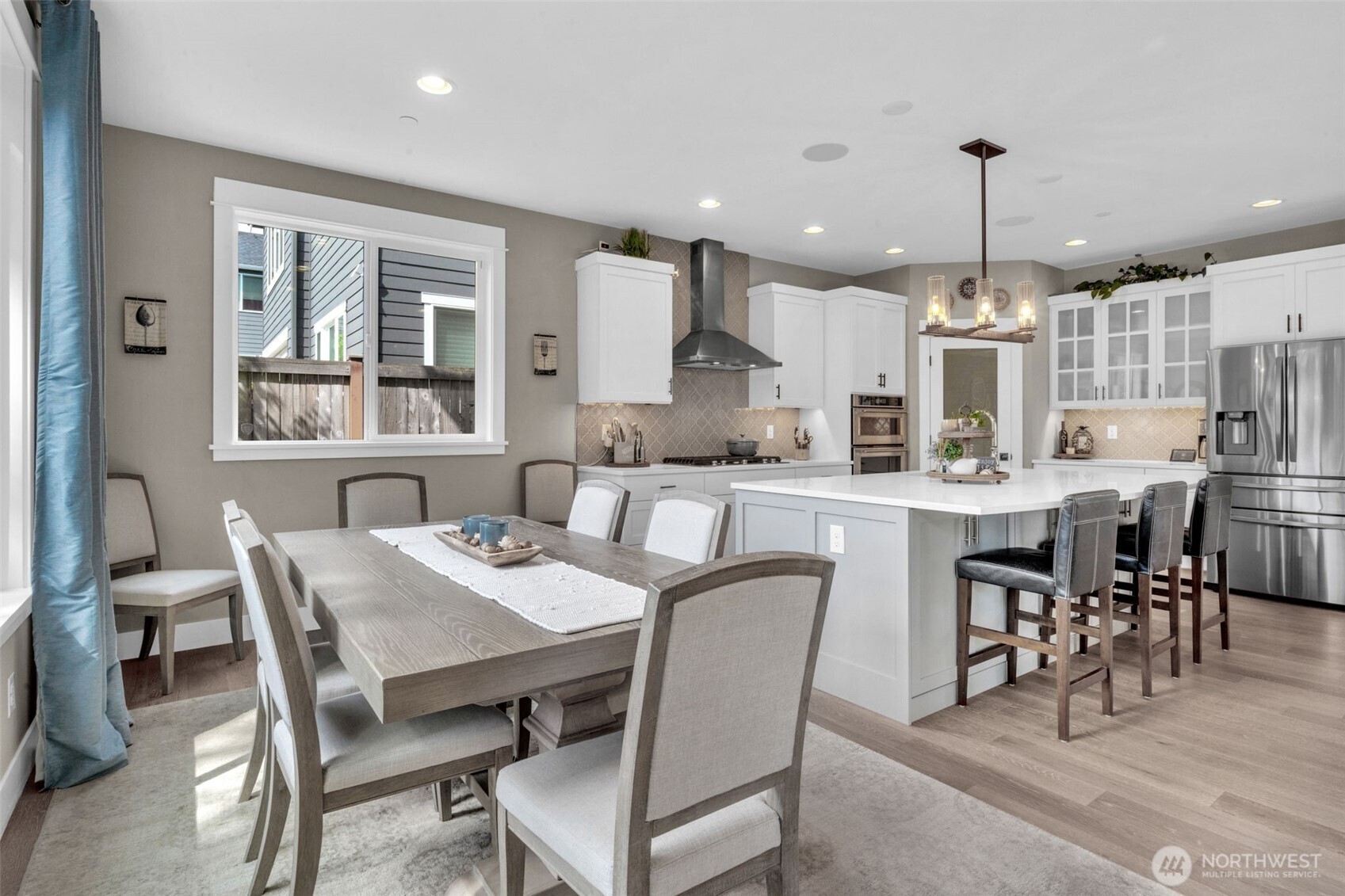 23216 9th Avenue Southeast Bothell, WA 98021 - Photo 12 of 40 a dining room with stainless steel appliances kitchen island granite countertop a dining table chairs and a refrigerator