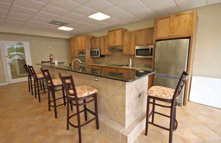909 Santa Rosa Boulevard, Unit 265 Fort Walton Beach, FL 32548 - Photo 16 of 18 a kitchen with stainless steel appliances granite countertop a table chairs and a refrigerator