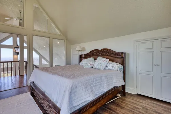 a spacious bedroom with a balcony a bed and a large window
