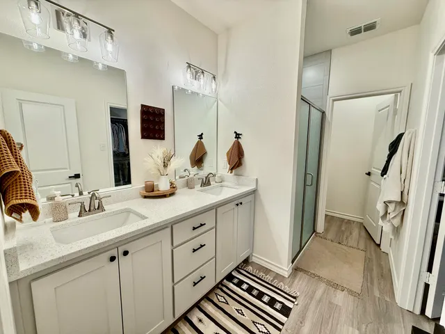 a bathroom with double vanity and a bathtub