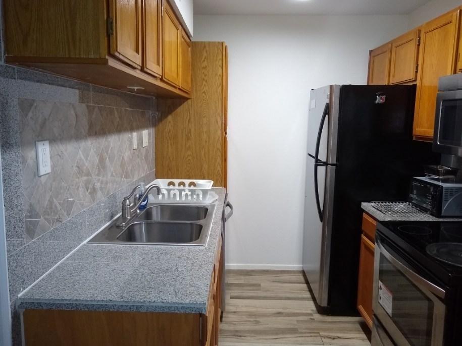 3115 Helms Street, Unit 308 Austin, TX 78705 - Photo 5 of 14 a kitchen with stainless steel appliances granite countertop a refrigerator and a stove