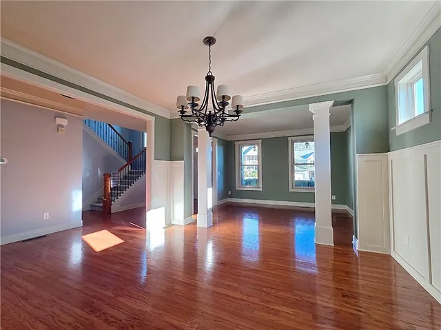 a view of a room with wooden flooring and windows