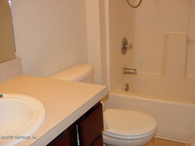 7920 Merrill Road, Unit 2015 Jacksonville, FL 32277 - Photo 3 of 5 a bathroom with a granite countertop sink toilet and bathtub