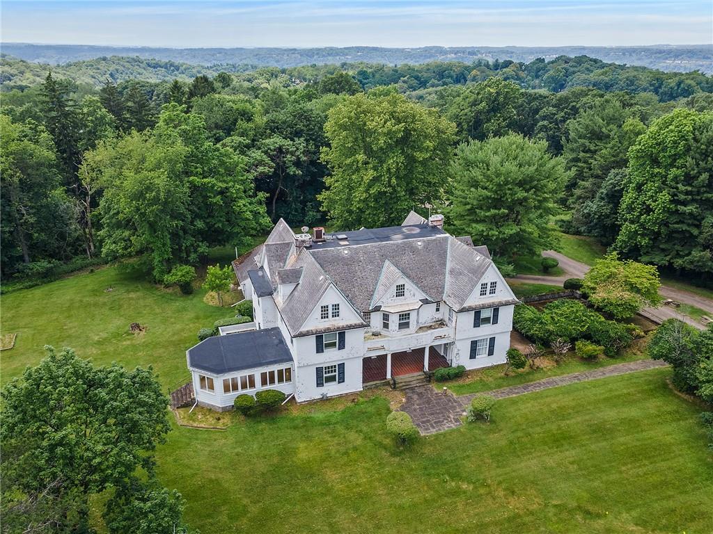 a white house with a big yard and large trees