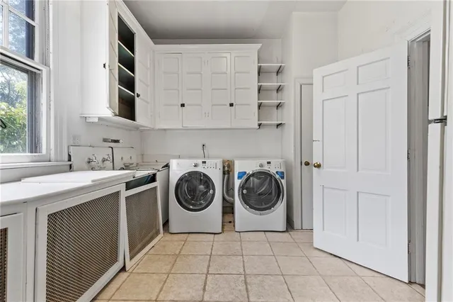 a utility room with cabinets washer and dryer