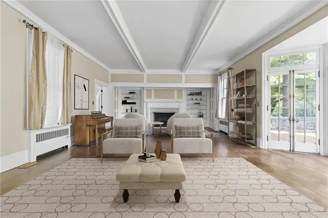 a living room with furniture large window and wooden floor